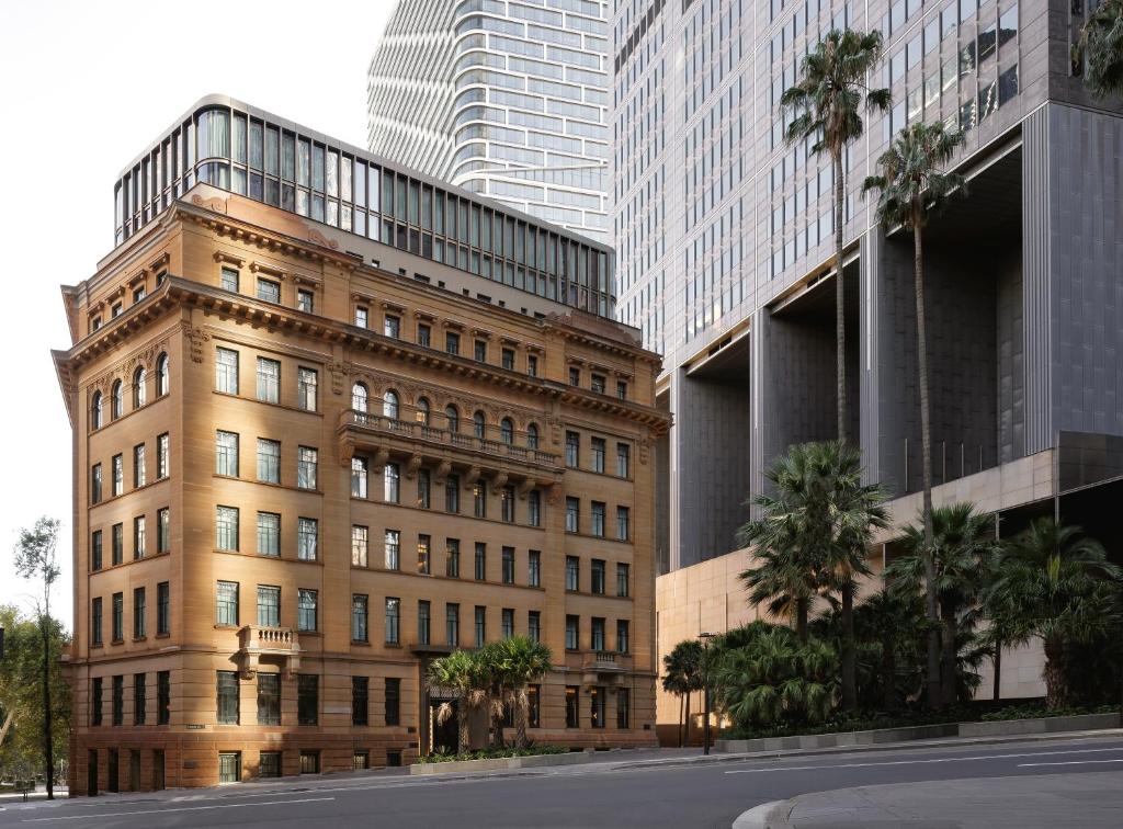 een gebouw met palmbomen voor hoge gebouwen bij Capella Sydney in Sydney