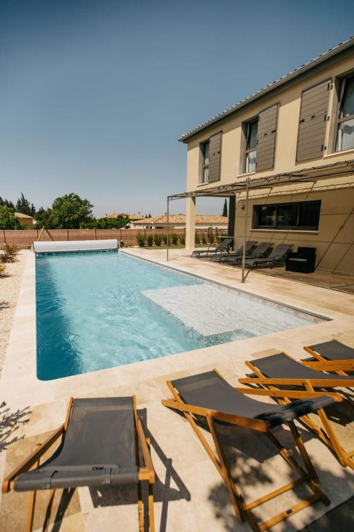 - deux chaises et une piscine en face d'un bâtiment dans l'établissement Villa Moka - private pool, à Saumane-de-Vaucluse