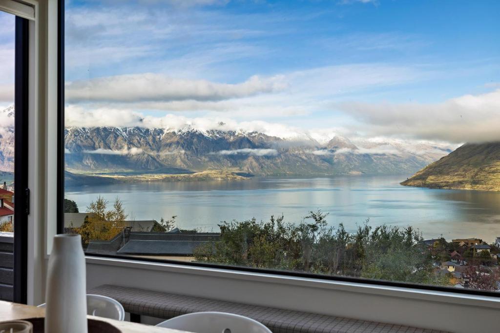 ventana con vistas al lago y a las montañas en Remarkable Alpine Holiday Home en Queenstown