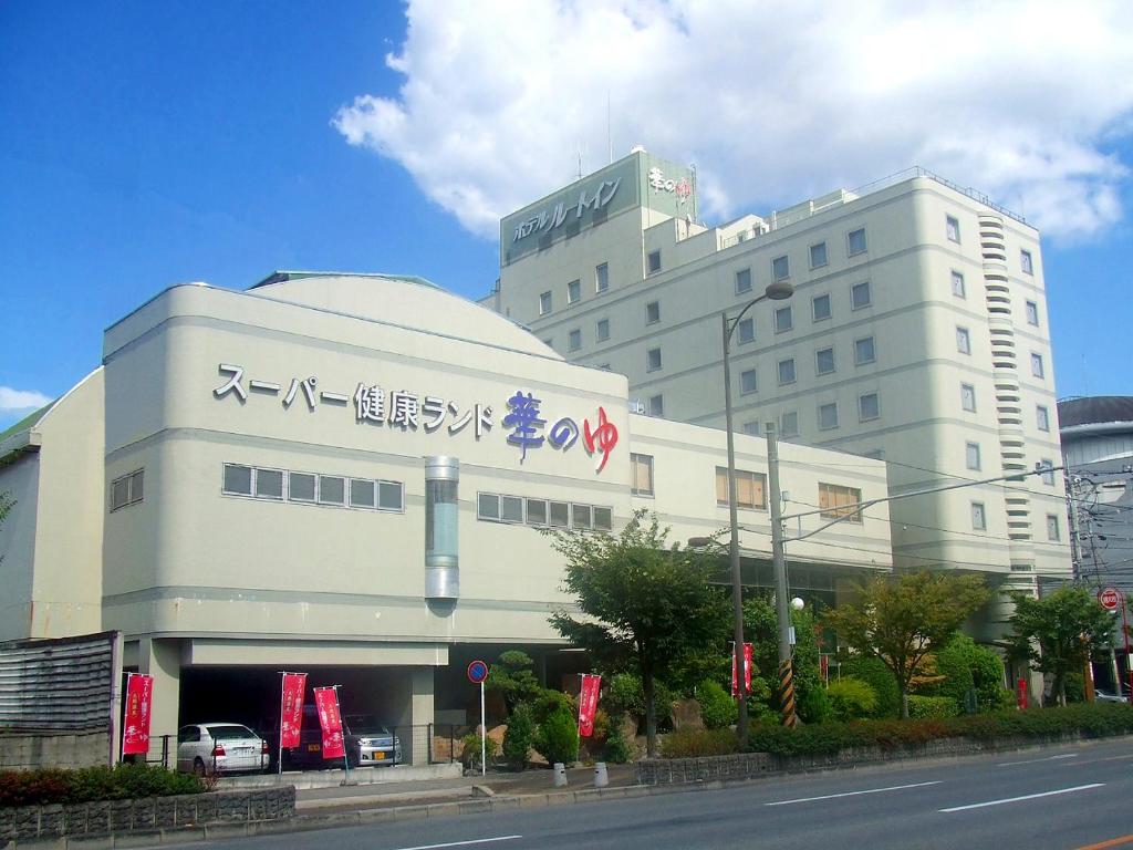 um grande edifício branco com escrita ao lado em Route Inn Grantia Fukuyama Spa Resort em Fukuyama