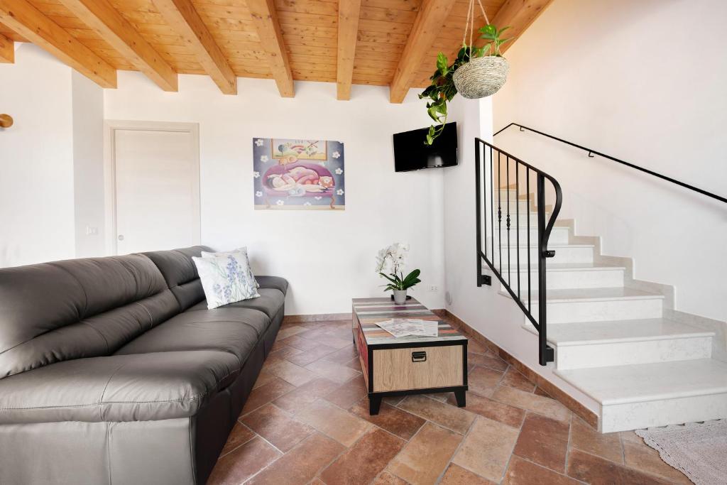 ein Wohnzimmer mit Sofa und Treppe in der Unterkunft Casale la Coccinella Lavanda in Caprino Veronese