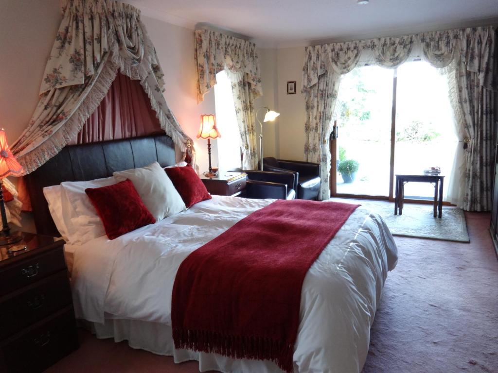 a bedroom with a large bed and a large window at Tigh Na Bruach B&B in Invermoriston
