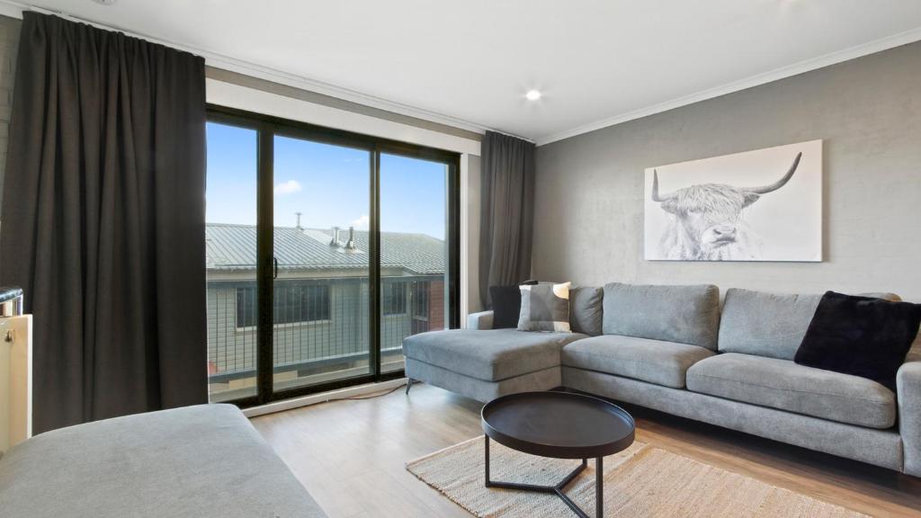 a living room with a couch and a large window at Lawlers 29 in Mount Hotham