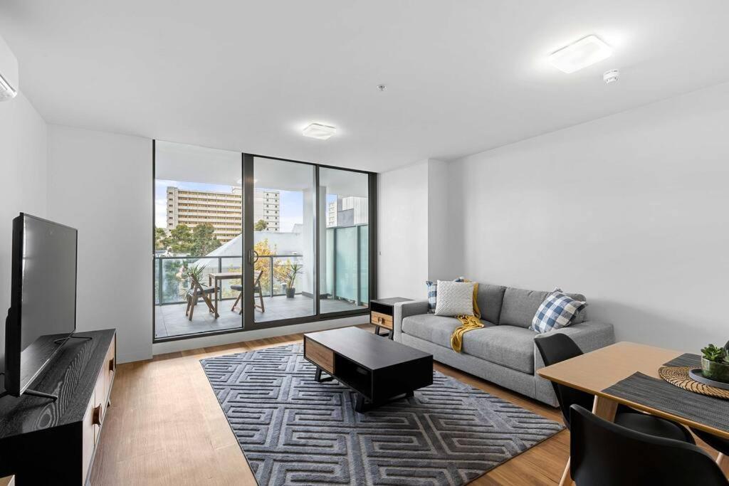 墨爾本的住宿－Perfect Urban Retreat!，客厅配有沙发和桌子