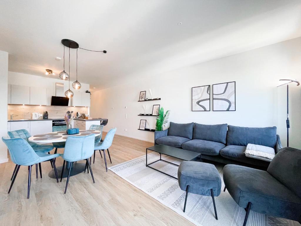 sala de estar con sofá, mesa y sillas en E&K living - 6 pers - design apartment - fair - congress - parking, en Augsburg