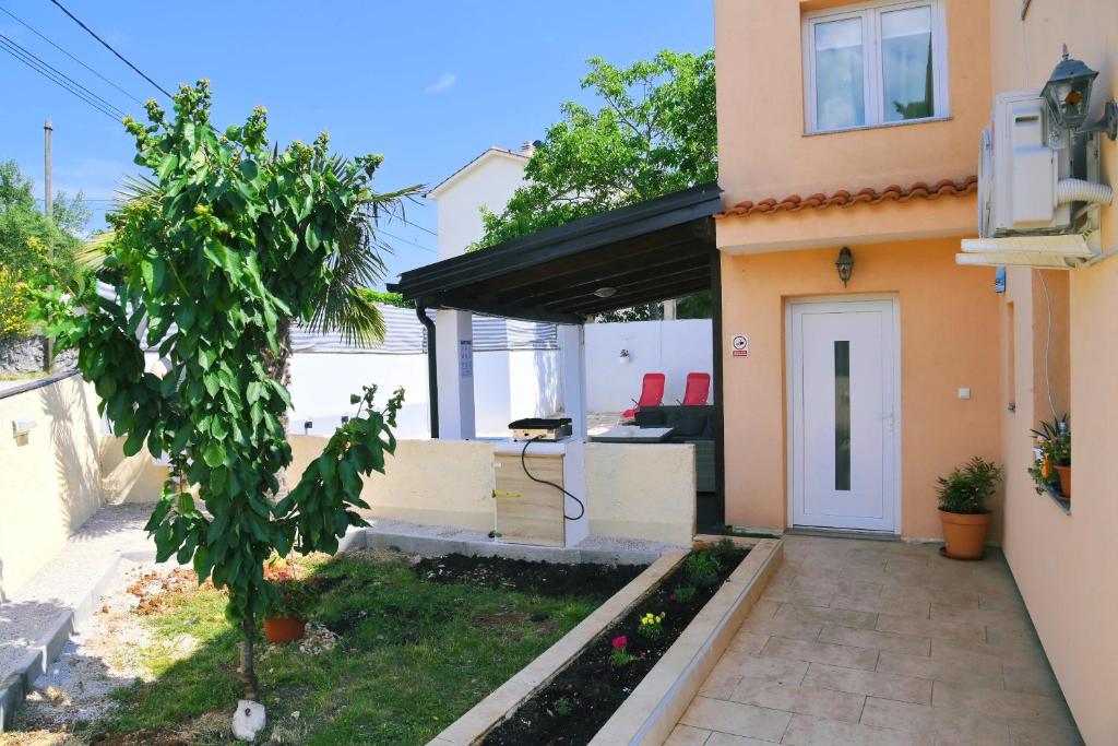 a house with a white door and a patio at Holiday Home Mumy in Gostinjac