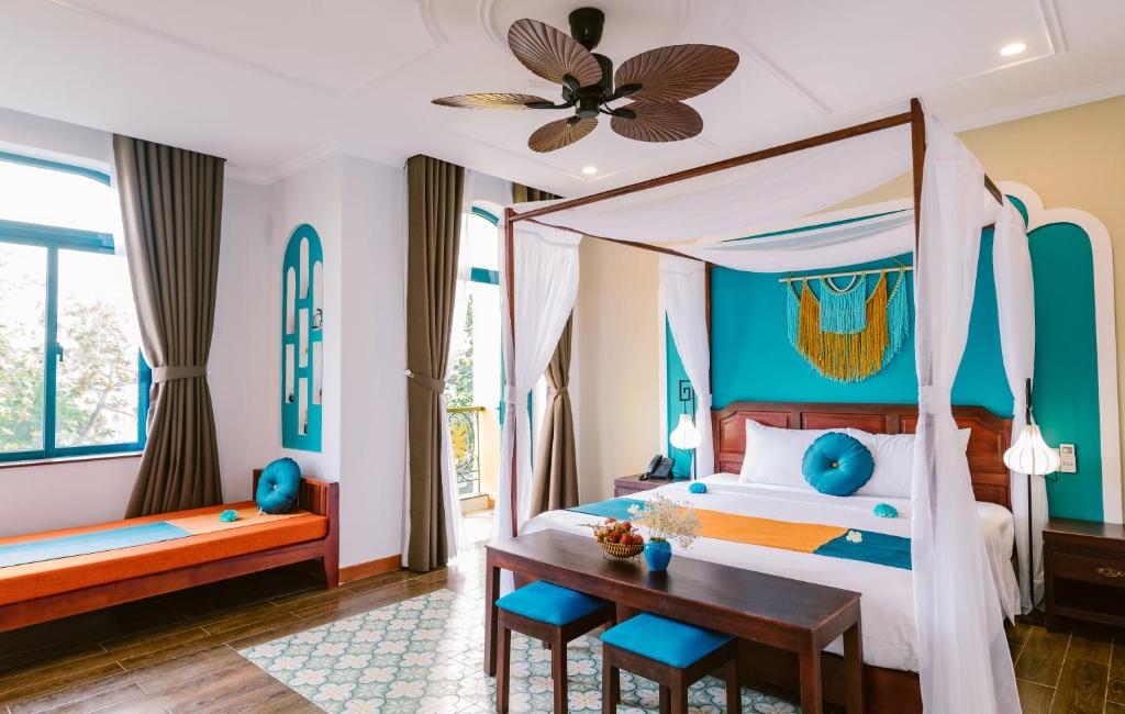a bedroom with a canopy bed and a table and chairs at Boutique Villa in Hoi An Oldtown in Hoi An