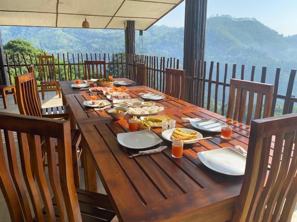 una mesa de madera con comida en la parte superior de un balcón en Brisk Ella Retreat en Ella