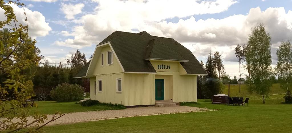 a small white house with a black roof at Viesu nams Bušelis in Turaida