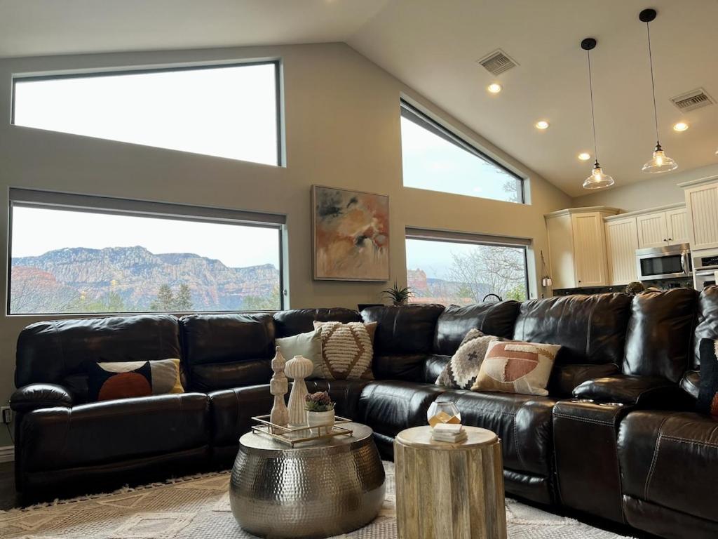 セドナにあるSedona Uptown Gem! Wow! Views!! Close to trails, walk to Uptown Sedona, restaurants and shoppingのリビングルーム(黒い革張りのソファ、窓2つ付)