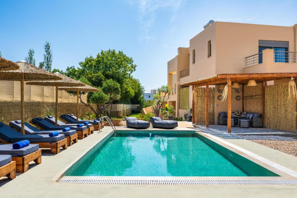 uma piscina com espreguiçadeiras e uma casa em Villa Anolia with Private Pool em Koskinou