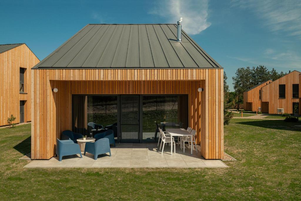 a wooden shed with a table and chairs in a yard at Morze Sasino in Sasino