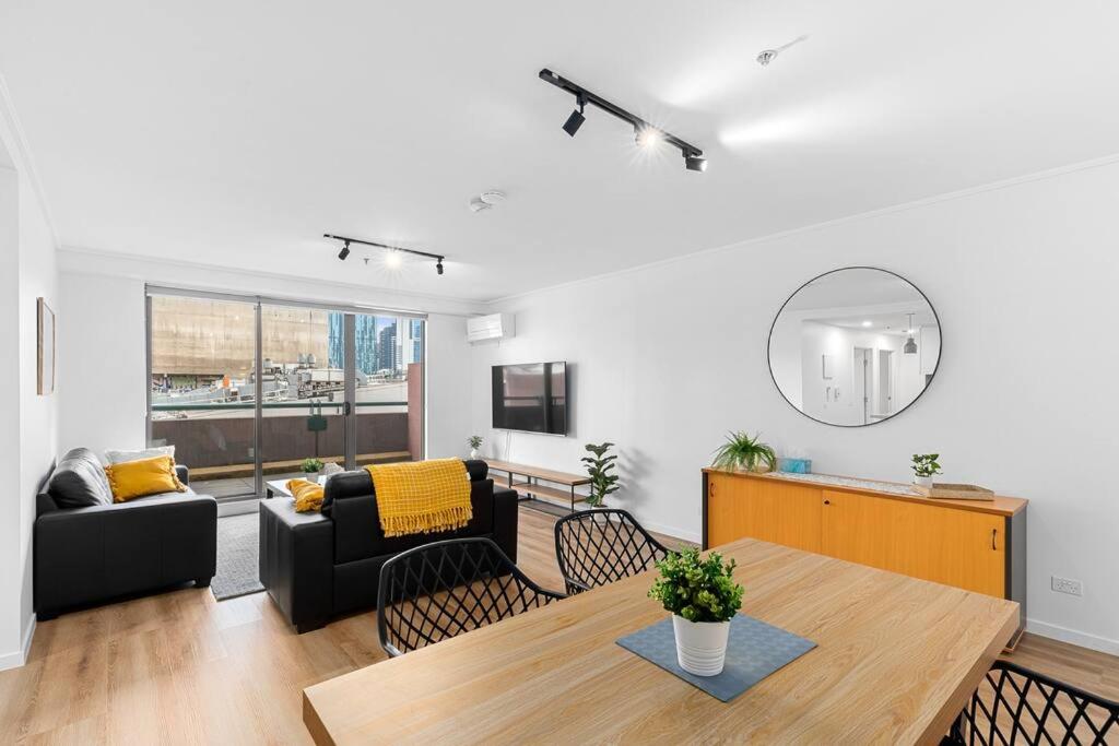 2-Bedroom Apartment in Paris End of Melbourne CBD في ملبورن: غرفة معيشة مع طاولة وأريكة