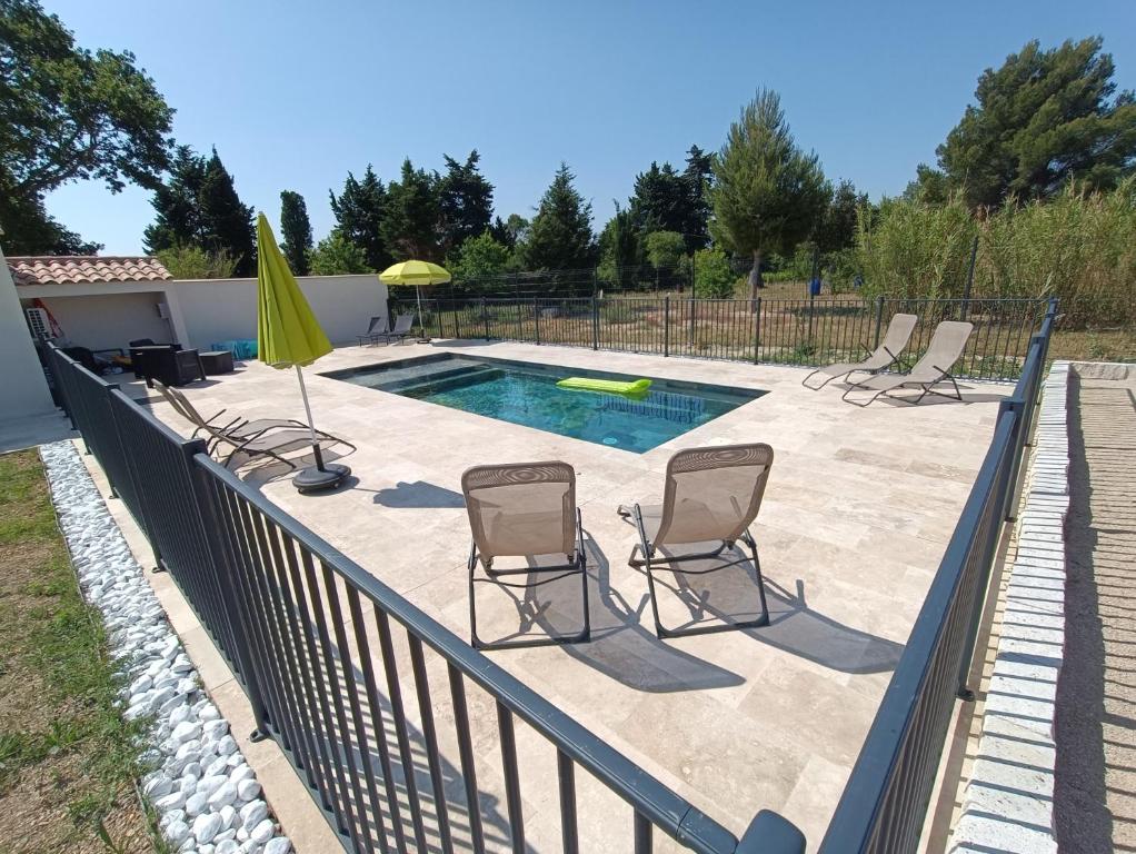 um pátio com cadeiras e uma piscina em Maison indépendante avec piscine, 10min Avignon em Pujaut