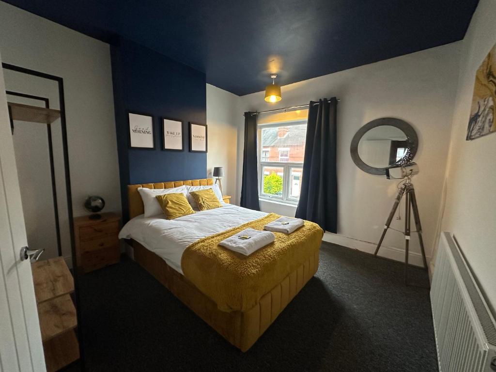 een slaapkamer met een bed met een spiegel en een camera bij Westwood Place in Spon End