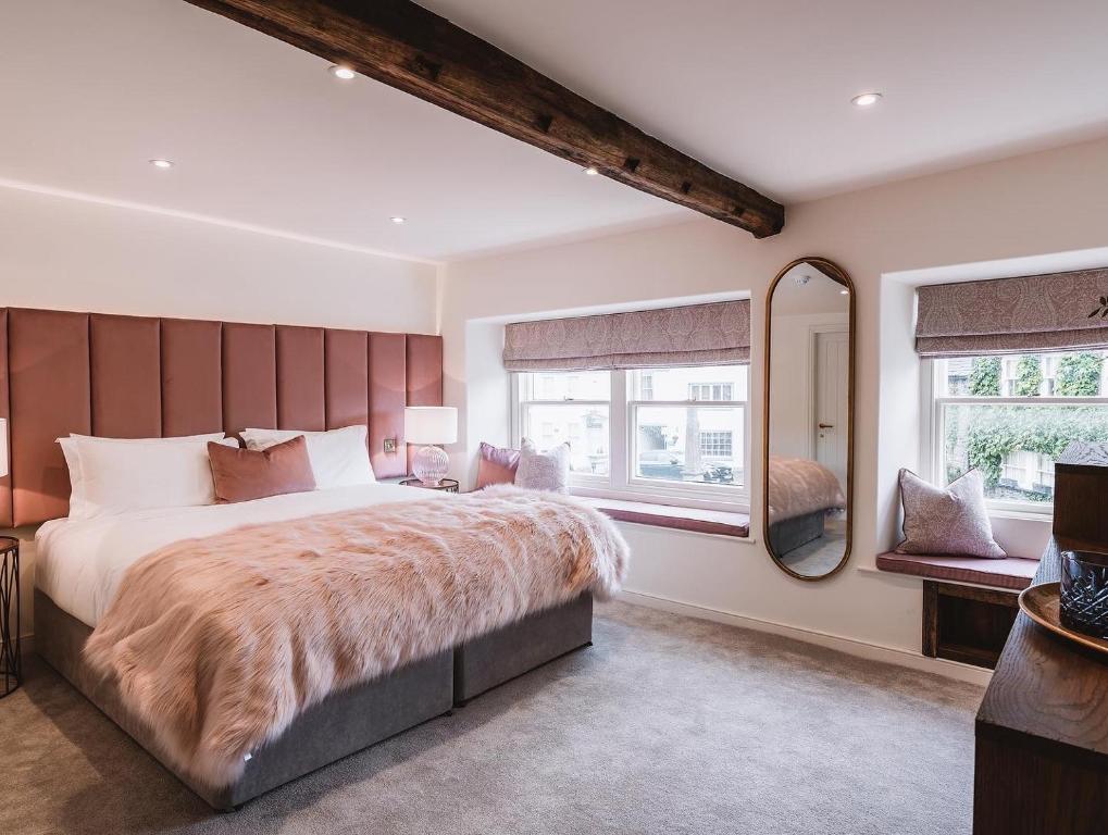 ein Schlafzimmer mit einem großen Bett und einem großen Spiegel in der Unterkunft Coffee & Stays at Cartmel Square in Cartmel