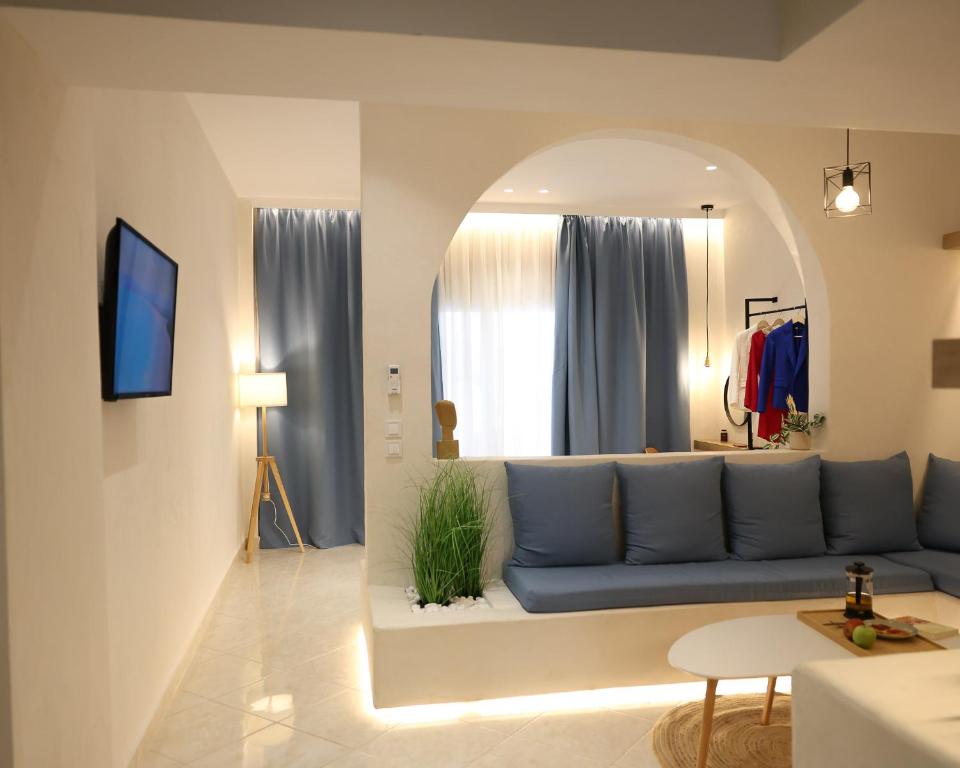 een woonkamer met een blauwe bank en een spiegel bij Thermes private suites in Loutraki