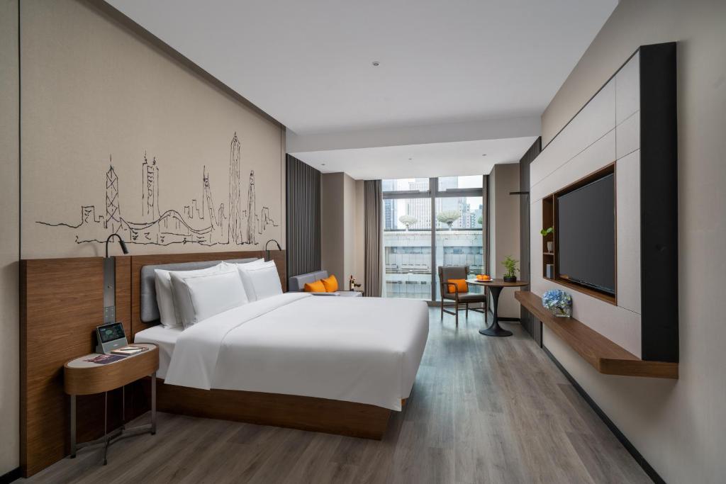 Un pat sau paturi într-o cameră la UrCove by HYATT Futian CBD-毗邻福田站和星河COCO Park 尊享免费迷你吧