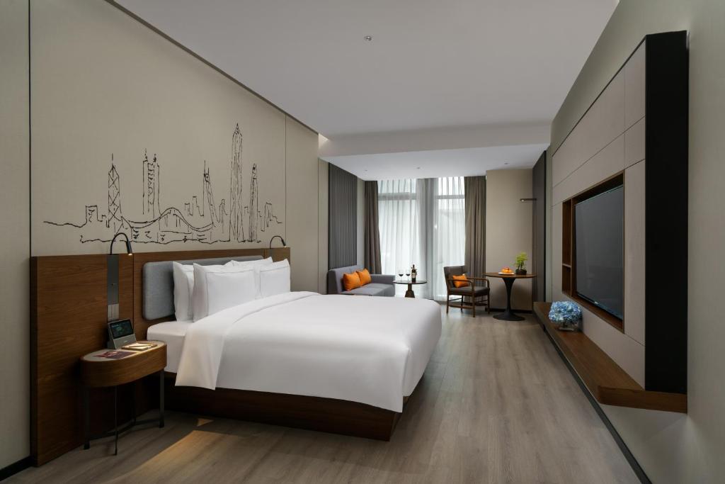 Un pat sau paturi într-o cameră la UrCove by HYATT Futian CBD-毗邻福田站和星河COCO Park 尊享免费迷你吧