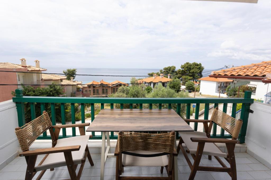 un tavolo e sedie su un balcone con vista di D&G Apartments ad Ayía Paraskeví