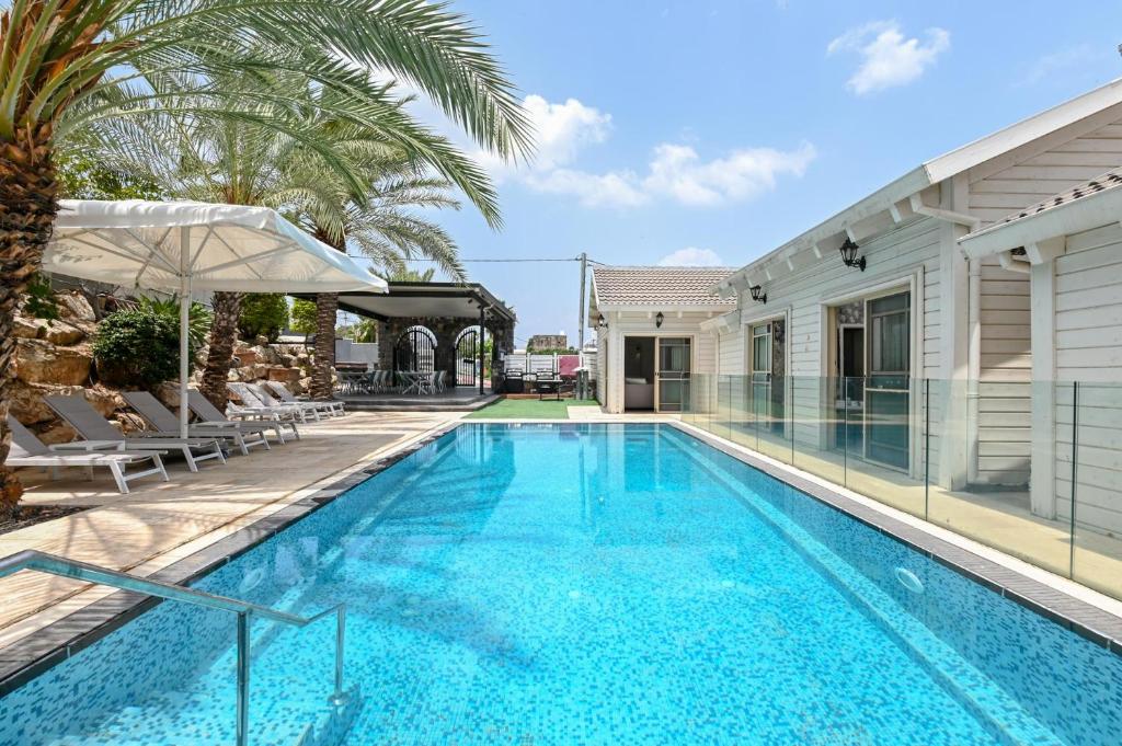 uma piscina com uma villa e uma casa em YalaRent Liri Resort - a beautiful resort complex in Tiberias em Tiberias