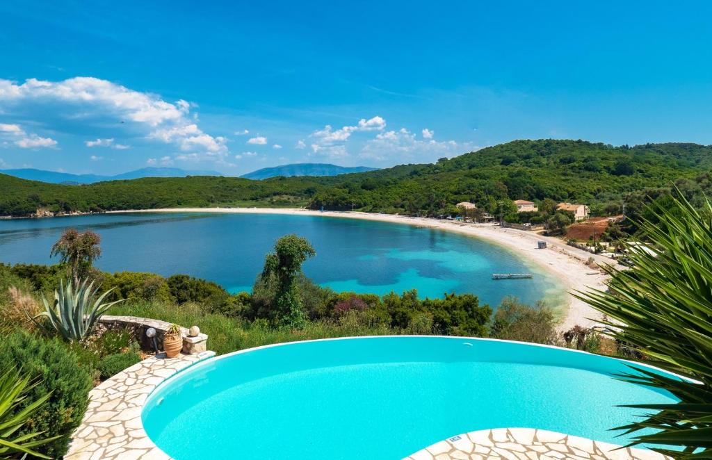 Villa Georgia في Ágios Stéfanos: مسبح بجانب شاطئ بجسم ماء