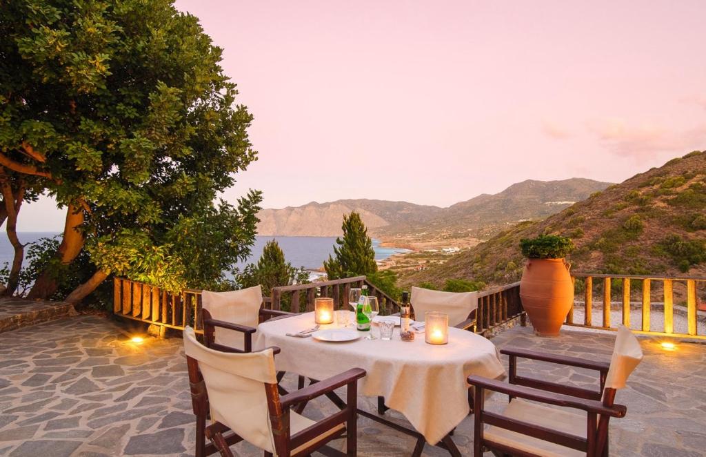 a table and chairs on a patio with a view at Villa Fegari in Mochlos