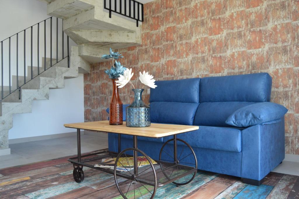 Sofá azul en la sala de estar con mesa en O Cabanel de Pepe, en Muxía