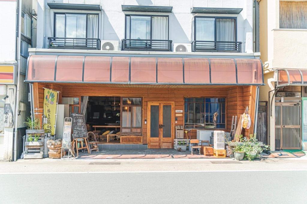 a store front of a building with tables and chairs at 暮らす実験室 in Taketa