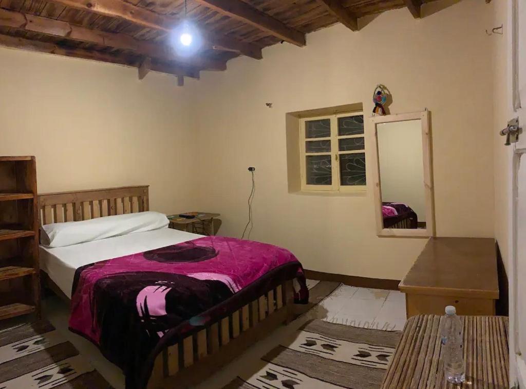 - une chambre avec un grand lit et un miroir dans l'établissement Al Kahina Gardens, Retreat and Resort, à Siwa