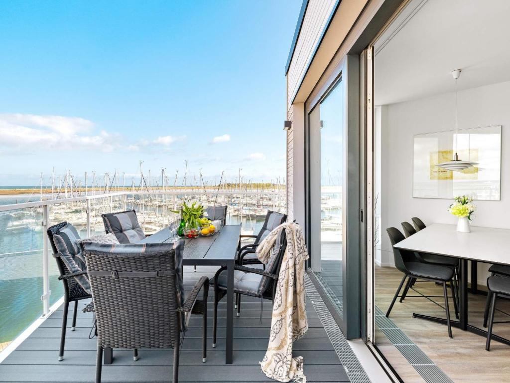 a dining room with a table and chairs on a balcony at Moderne Ferienwohnung direkt am Meer in Wendtorf