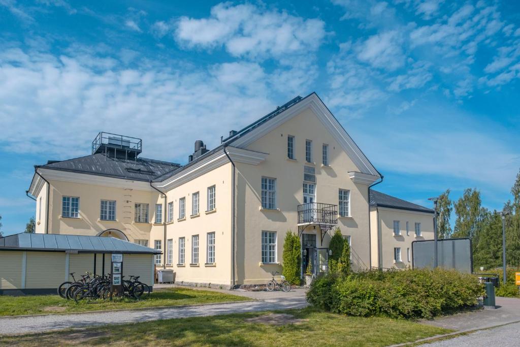 un gran edificio blanco con bicicletas estacionadas frente a él en Hyvärilä Youth- and Holiday Centre en Nurmes