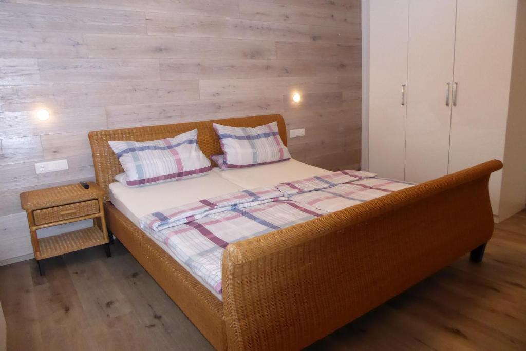 a wicker bed with two pillows on it in a bedroom at Ferienwohnung am Bacherl in Surberg