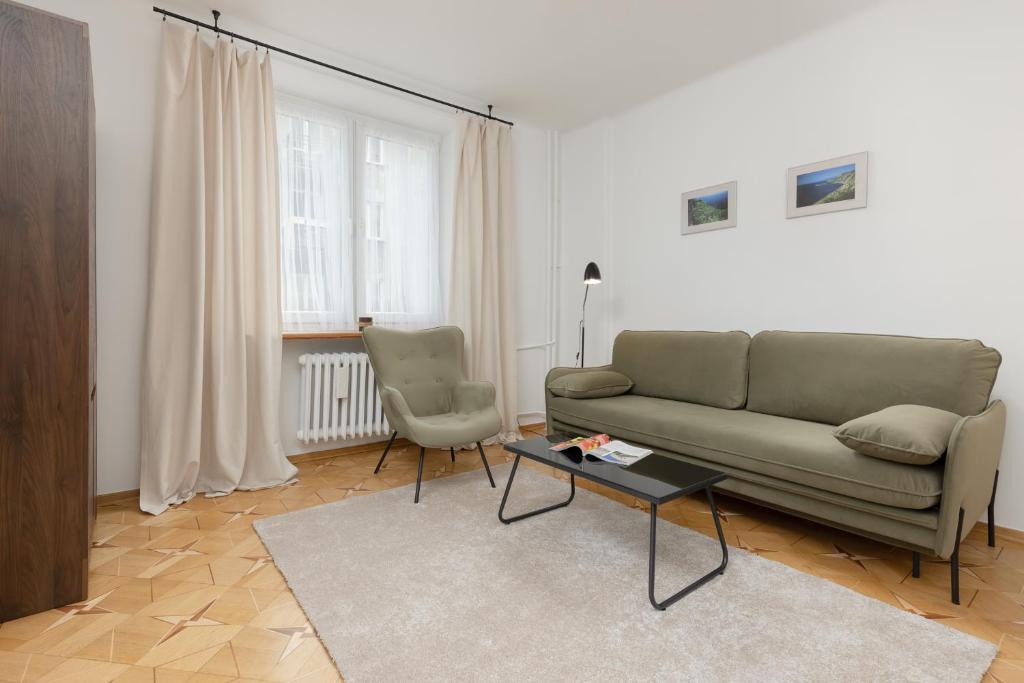 ein Wohnzimmer mit einem Sofa und einem Tisch in der Unterkunft Bałuckiego Apartment Stary Mokotów Warsaw by Renters in Warschau