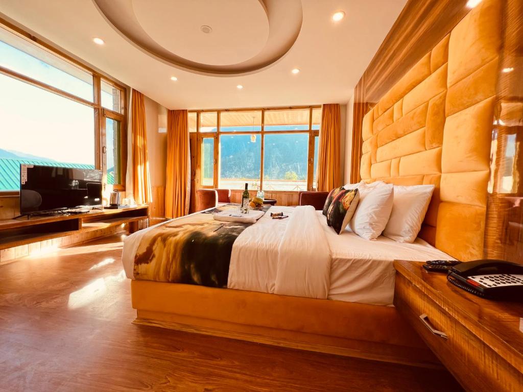Hill River Resort - Central Heated & Air cooled في مانالي: غرفة نوم بسرير كبير وتلفزيون