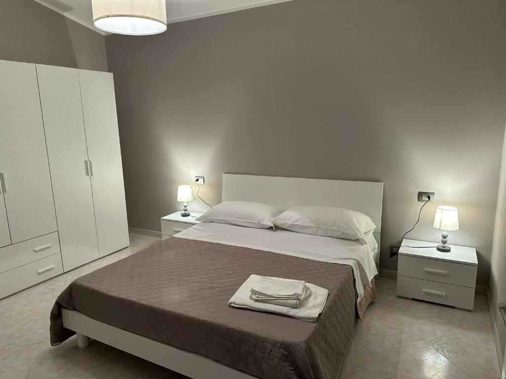 a bedroom with a bed with two night stands and two lamps at Le Palme di Riace 1 in Riace Marina