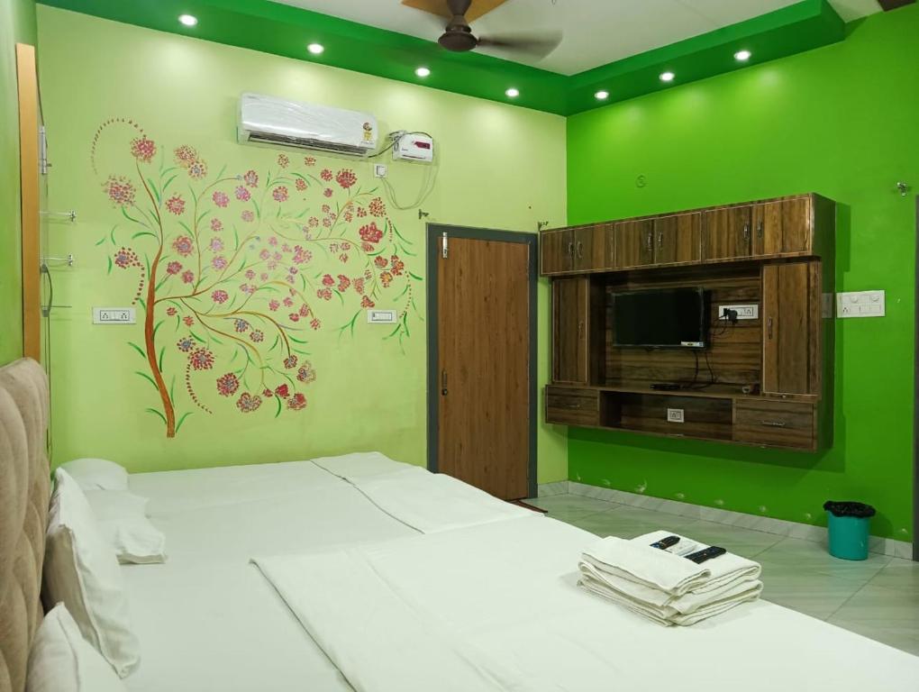 a bedroom with a bed and a green wall at Trinetra Inn in Varanasi