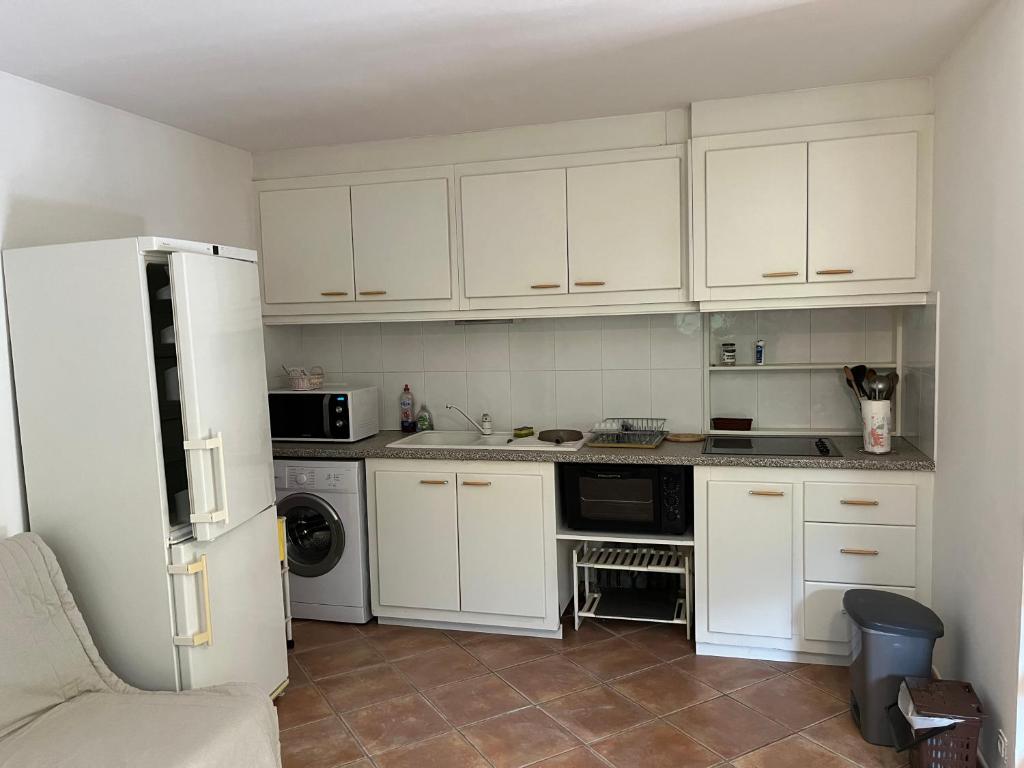 a kitchen with white cabinets and a white refrigerator at Corte Appartement T2 en résidence privée in Corte