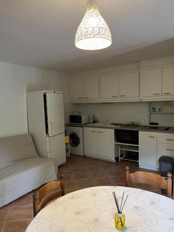 a kitchen with white cabinets and a table and a dining room at Corte Appartement T2 en résidence privée in Corte