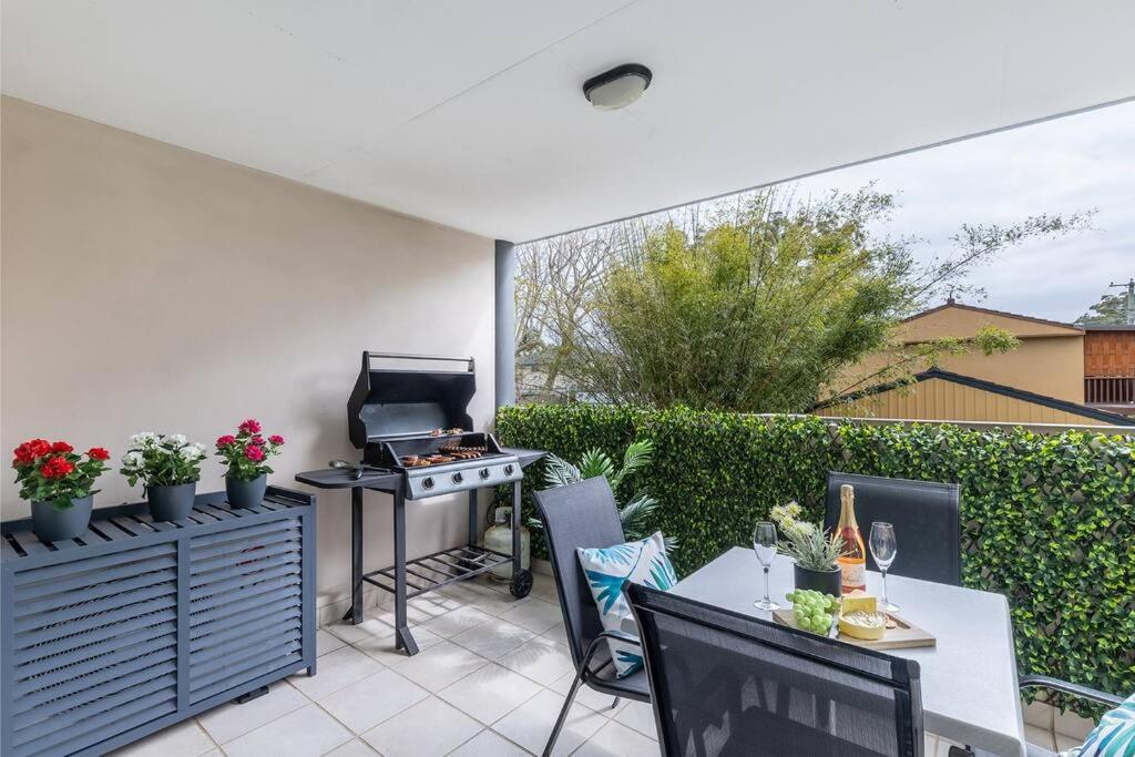a patio with a grill and a table and chairs at MikaLex - Walking distance from the beach! in Nelson Bay