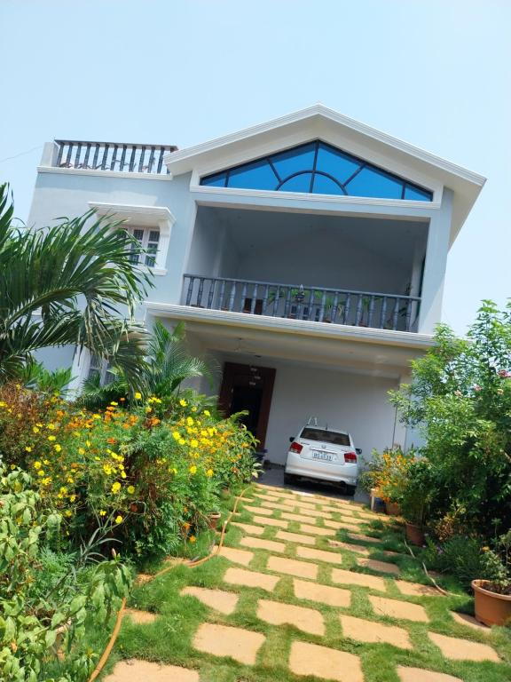 una casa con una macchina parcheggiata di fronte di Mirnalini Homestays a Mamallapuram