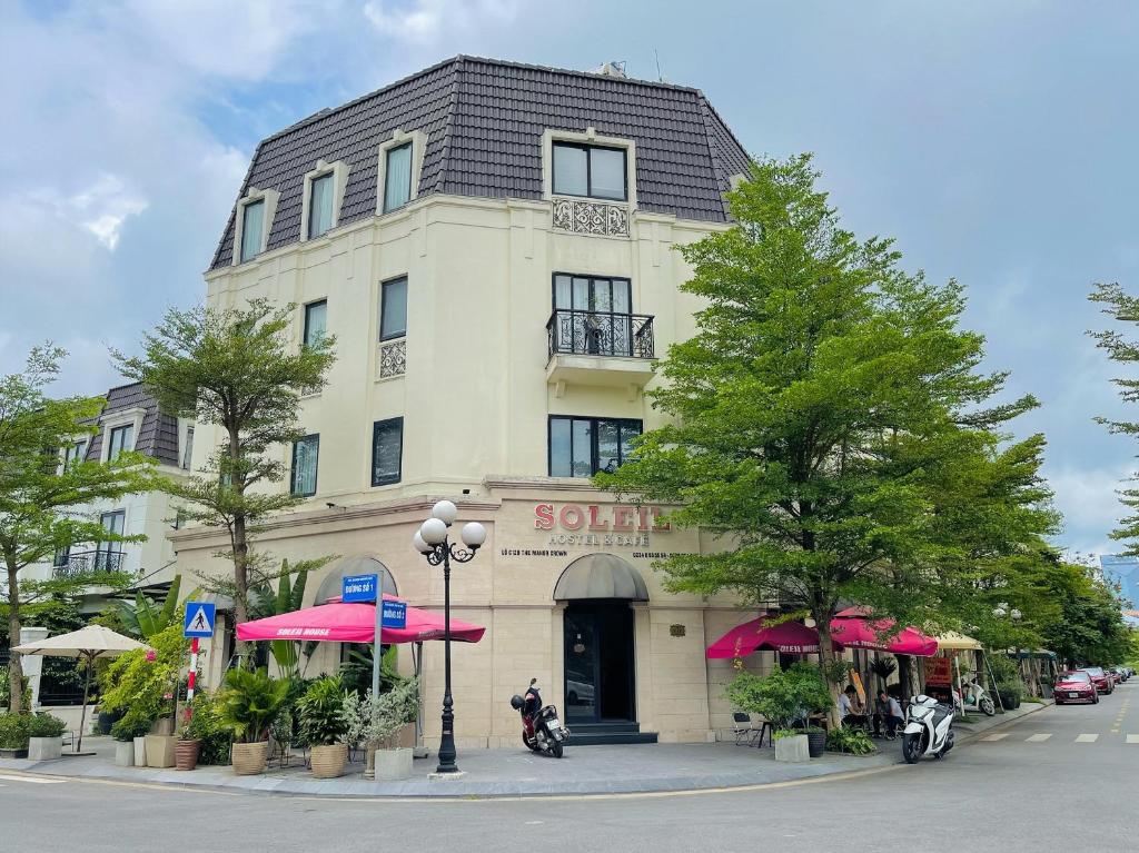 a building with pink umbrellas in front of it at SOLEIL HOSTEL in Hue