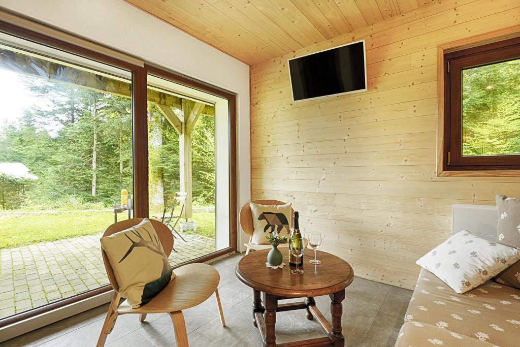 sala de estar con mesa, sillas y TV en Le Schwarzwald - A proximité des stations de ski, en La Bresse