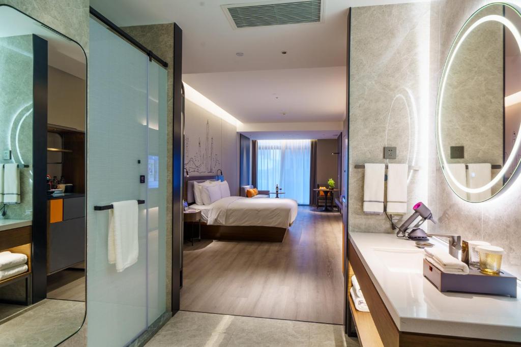 Un pat sau paturi într-o cameră la UrCove by HYATT Futian CBD-毗邻福田站和星河COCO Park 尊享免费迷你吧