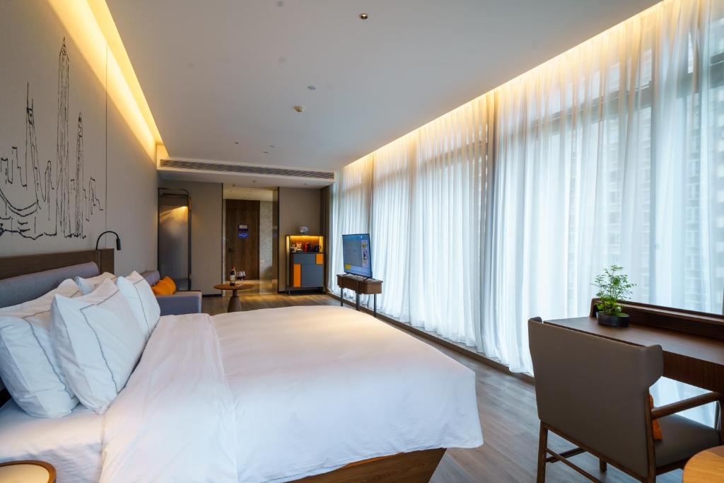 Un pat sau paturi într-o cameră la UrCove by HYATT Futian CBD-毗邻福田站和星河COCO Park 尊享免费迷你吧