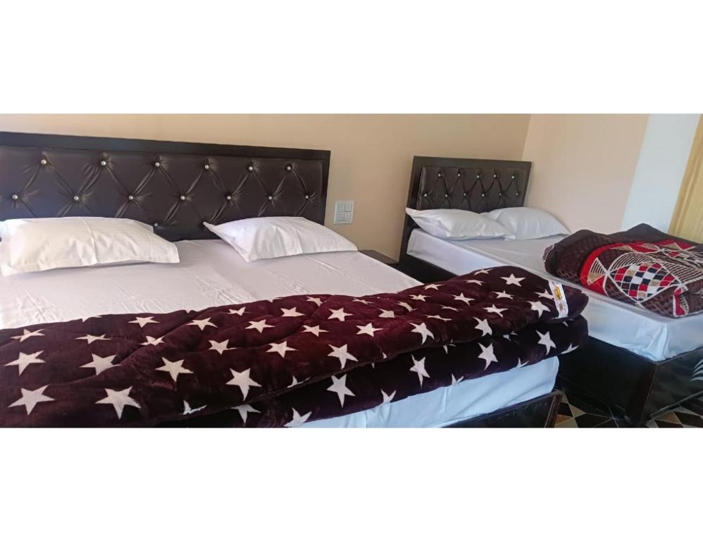 Dos camas en una habitación con una manta de bandera americana en Anjali Homestay, Ukhimath en Ukhimath