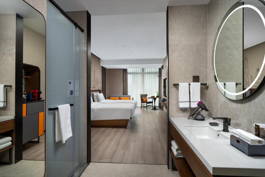 Un pat sau paturi într-o cameră la UrCove by HYATT Futian CBD-毗邻福田站和星河COCO Park 尊享免费迷你吧