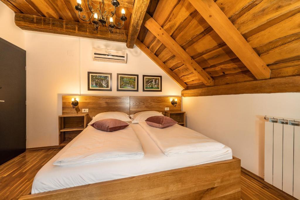 ein großes Bett in einem Zimmer mit Holzdecken in der Unterkunft B&B Plitvica Lodge in Plitvica Selo