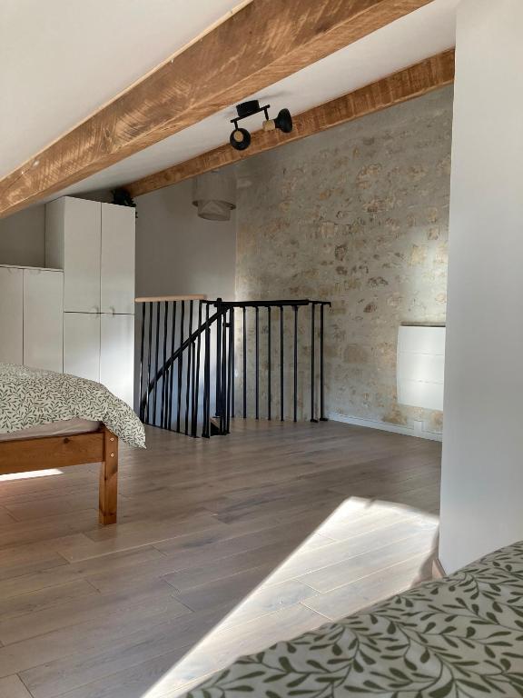a bedroom with a bed and a brick wall at Le Clos des Grands Frênes in Pons