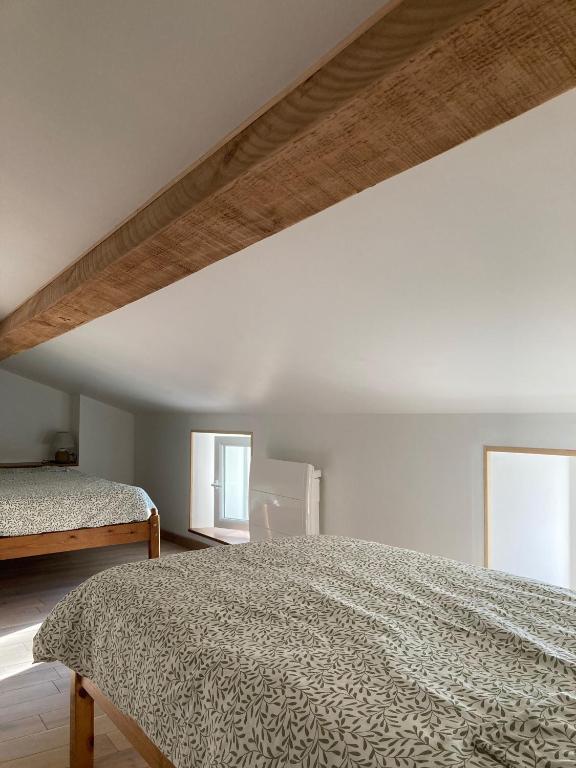 a bedroom with a large bed and two windows at Le Clos des Grands Frênes in Pons